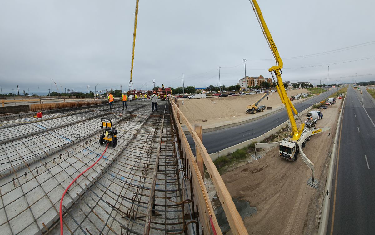 Bridge deck rebar mat and concrete pump during a nighttime concrete placement