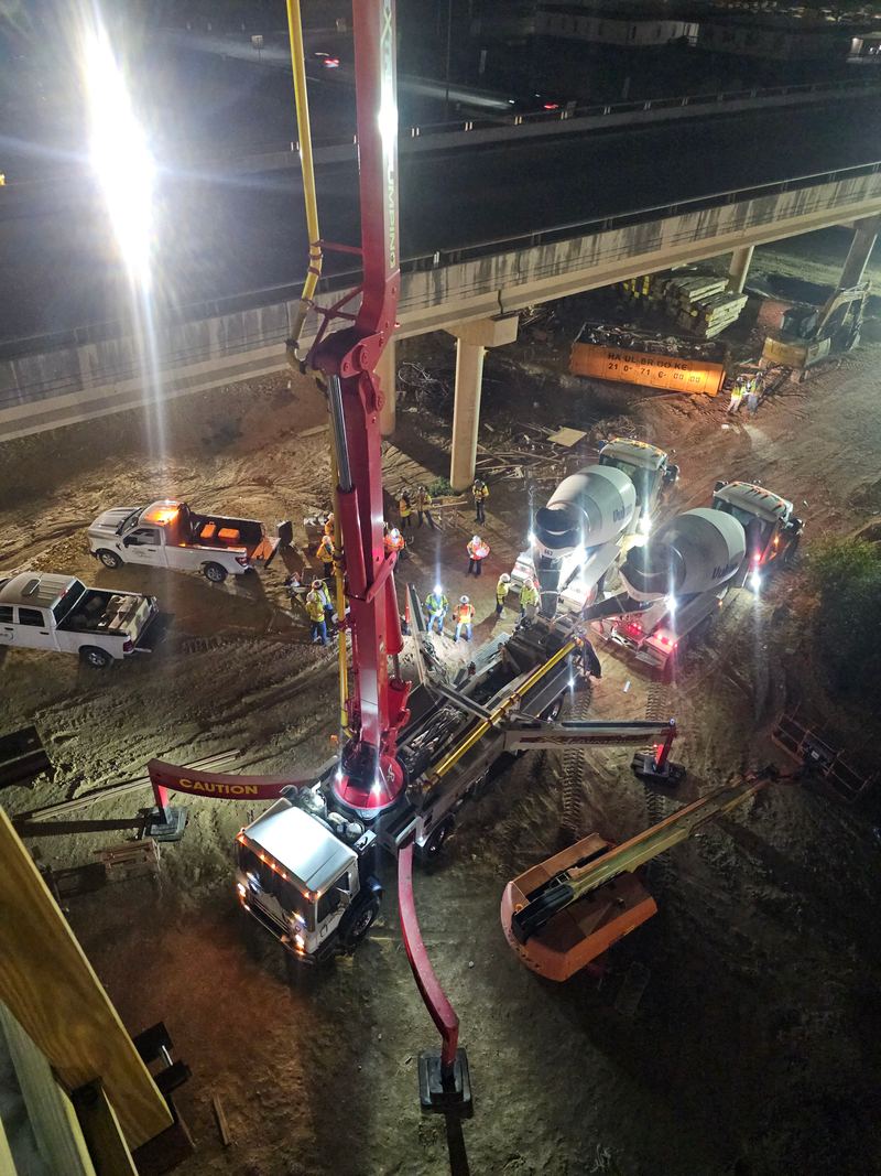 Crane setting a concrete girder span at night on a TxDOT bridge project